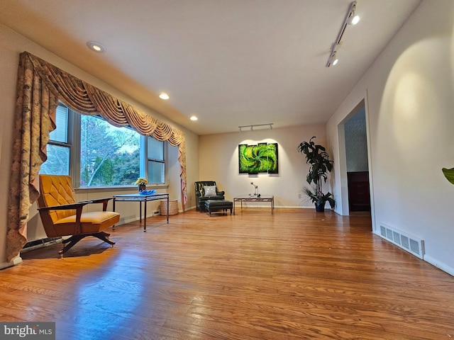 sitting room featuring hardwood / wood-style flooring and track lighting