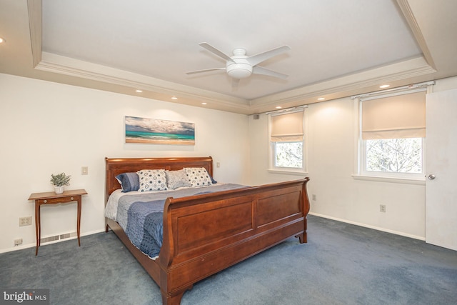 bedroom with ceiling fan, dark carpet, a raised ceiling, and ornamental molding