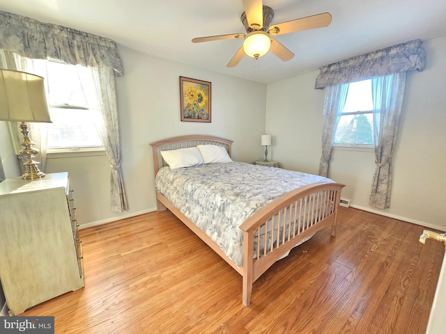 bedroom with multiple windows, ceiling fan, and light wood-type flooring