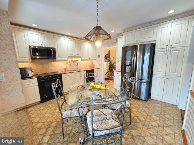 kitchen with pendant lighting, backsplash, sink, appliances with stainless steel finishes, and white cabinetry