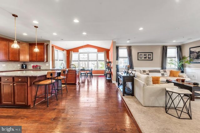 living room with dark hardwood / wood-style floors, lofted ceiling, and ornamental molding