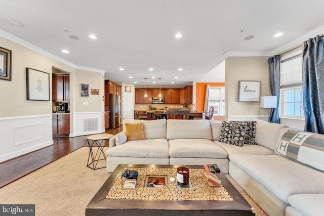 living room with a wealth of natural light, crown molding, and dark hardwood / wood-style floors