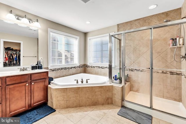 bathroom featuring tile patterned flooring, shower with separate bathtub, and vanity