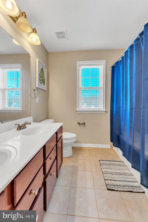 bathroom with tile patterned floors, vanity, and toilet