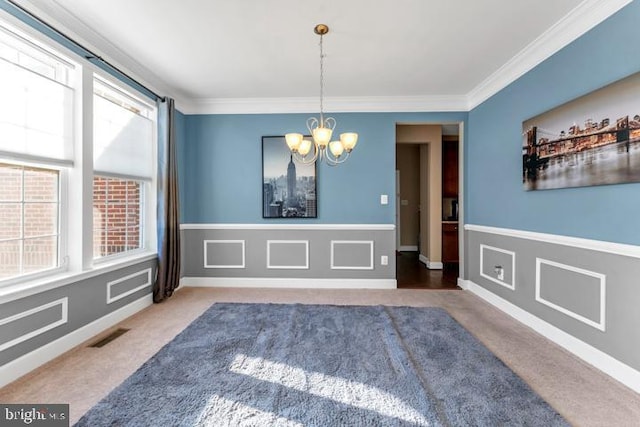 unfurnished dining area featuring carpet, ornamental molding, and a notable chandelier