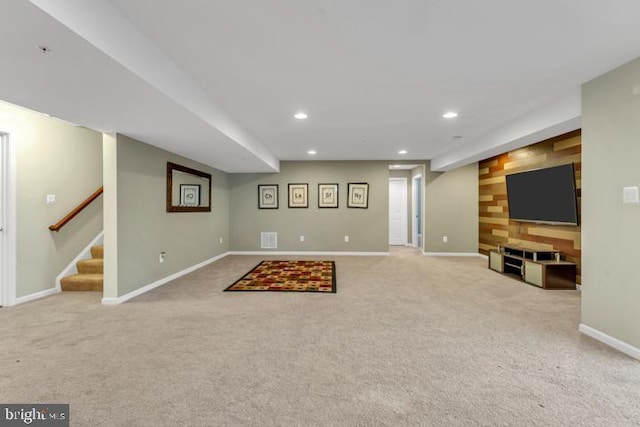 basement featuring light carpet and wooden walls