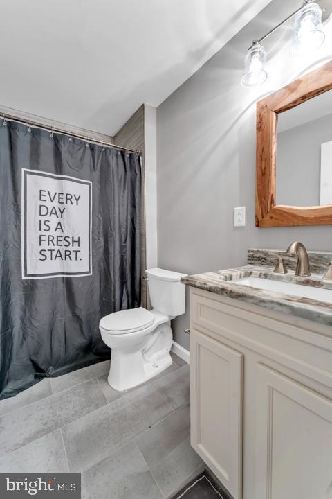 bathroom with a shower with curtain, vanity, and toilet