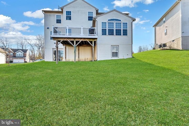 rear view of house with a lawn and a wooden deck