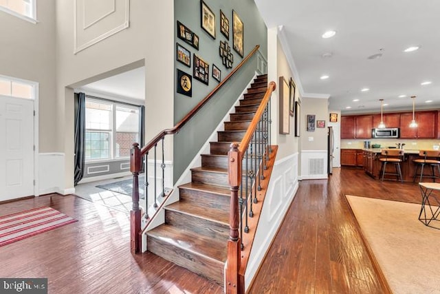 entrance foyer with dark hardwood / wood-style floors and ornamental molding