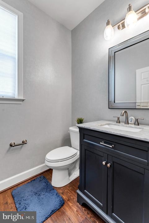 bathroom featuring hardwood / wood-style floors, vanity, and toilet