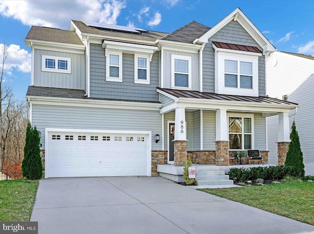 craftsman house with covered porch, a garage, and solar panels