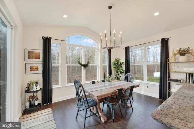 dining space with dark hardwood / wood-style flooring, lofted ceiling, and an inviting chandelier