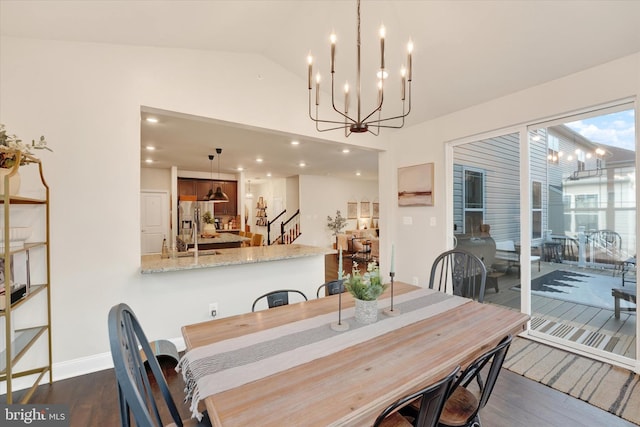 dining space with dark hardwood / wood-style flooring, lofted ceiling, and an inviting chandelier