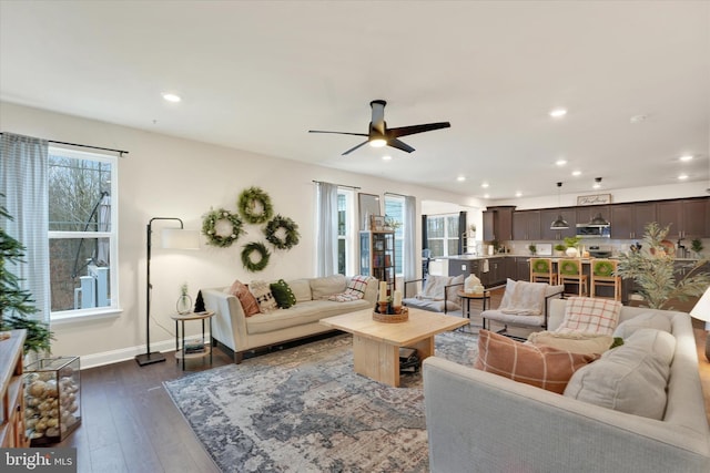 living room featuring dark hardwood / wood-style flooring and ceiling fan