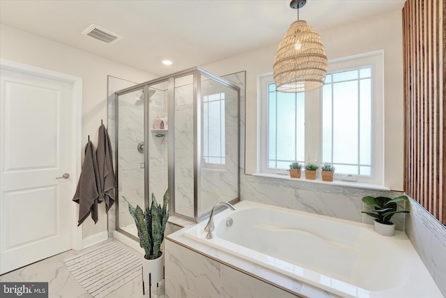 bathroom featuring separate shower and tub and a healthy amount of sunlight