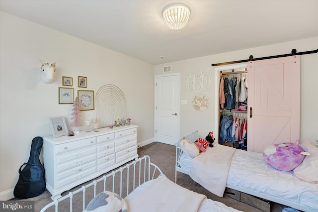 bedroom featuring carpet, a barn door, and a closet