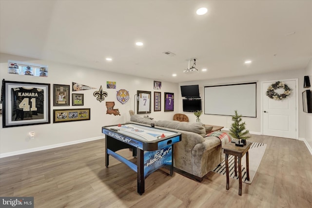 home theater featuring a notable chandelier and light hardwood / wood-style floors