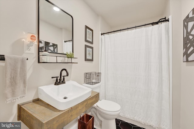 bathroom featuring tile patterned floors, curtained shower, toilet, and sink