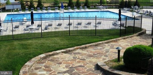 view of swimming pool with a patio and a lawn