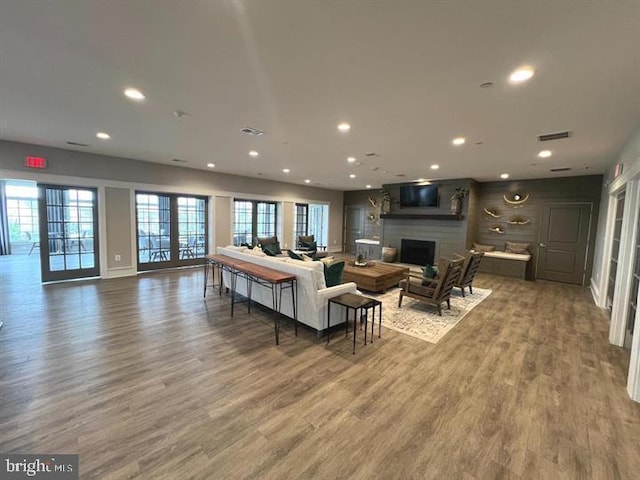 living room with french doors, a large fireplace, and dark hardwood / wood-style floors