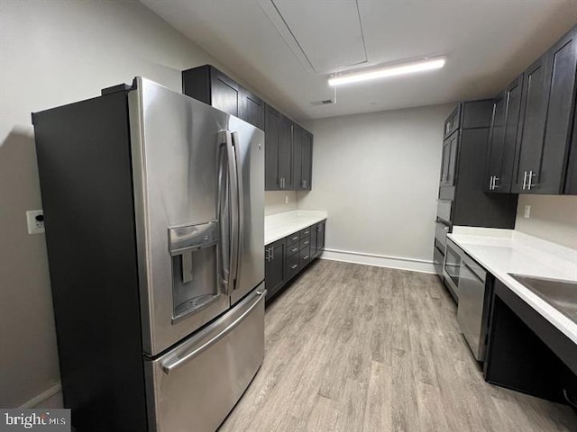 kitchen with sink, stainless steel appliances, and light wood-type flooring