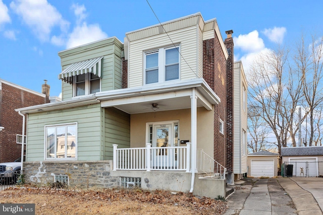 townhome / multi-family property with covered porch, a garage, and an outdoor structure