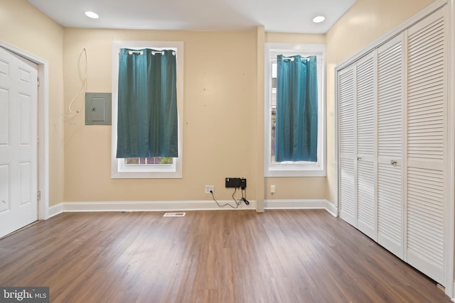 unfurnished bedroom with electric panel and dark wood-type flooring