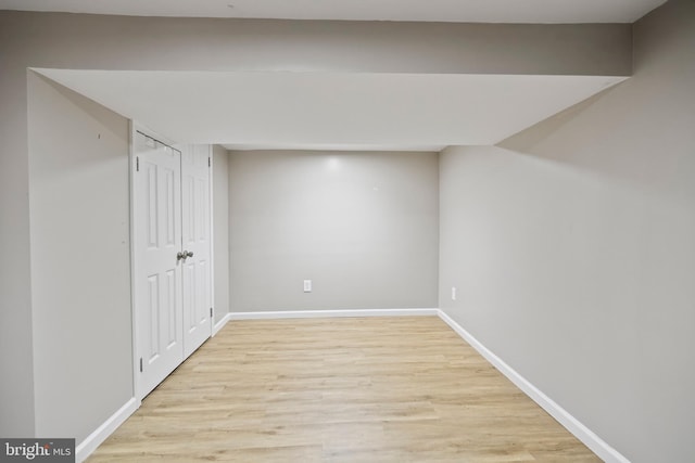 basement with light hardwood / wood-style flooring