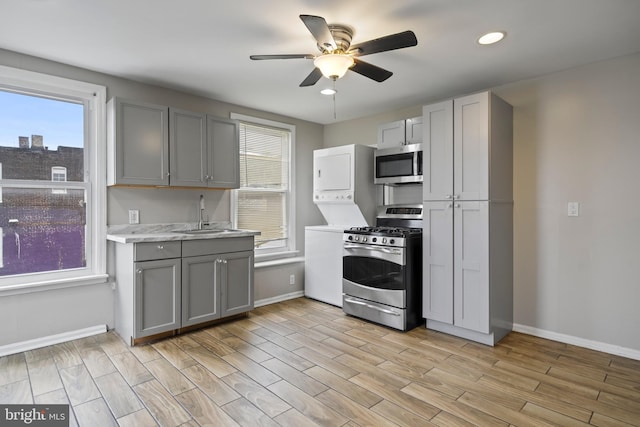 kitchen featuring gray cabinets, light wood-type flooring, sink, and appliances with stainless steel finishes