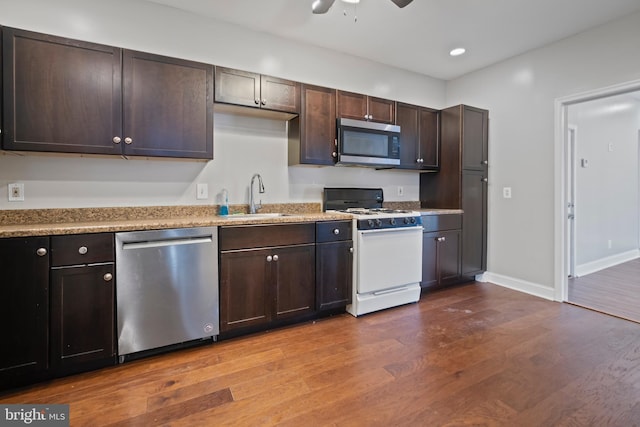 kitchen featuring sink, ceiling fan, appliances with stainless steel finishes, dark hardwood / wood-style flooring, and dark brown cabinetry