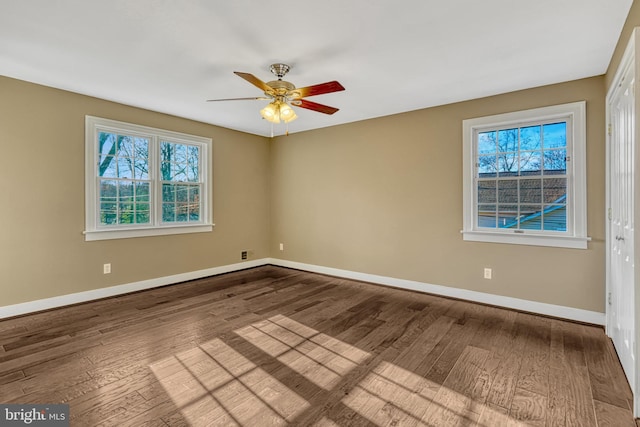 unfurnished room with a wealth of natural light, ceiling fan, and wood-type flooring