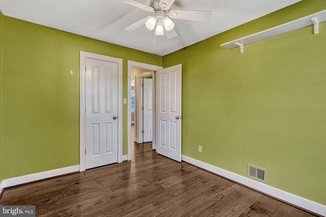 unfurnished bedroom featuring ceiling fan and dark hardwood / wood-style floors