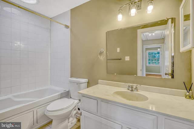 full bathroom featuring vanity, toilet, a textured ceiling, and tiled shower / bath