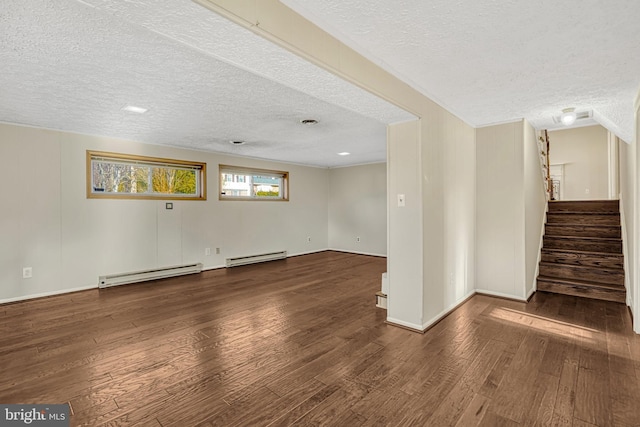 spare room with a textured ceiling, dark hardwood / wood-style floors, and a baseboard radiator