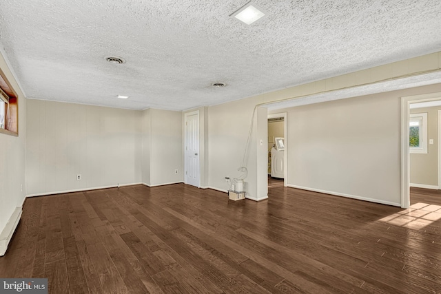 spare room featuring dark hardwood / wood-style flooring and a textured ceiling