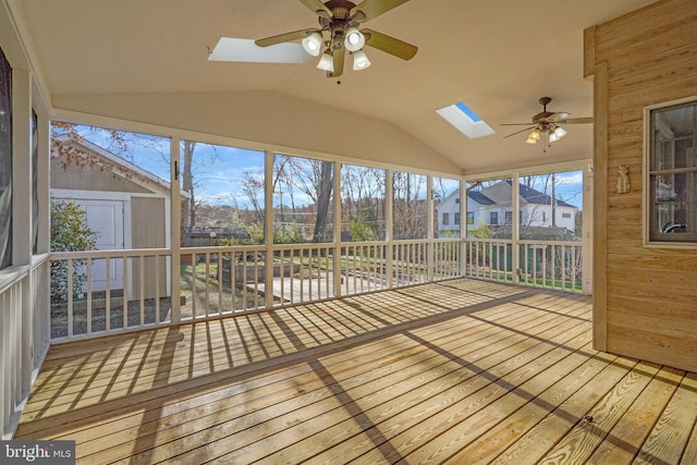 unfurnished sunroom with ceiling fan and lofted ceiling with skylight