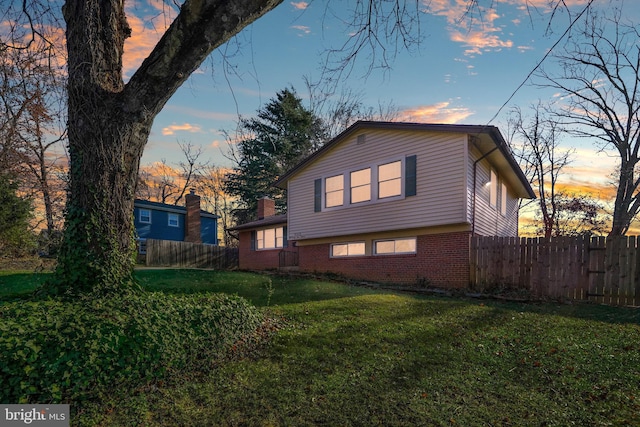 property exterior at dusk with a yard