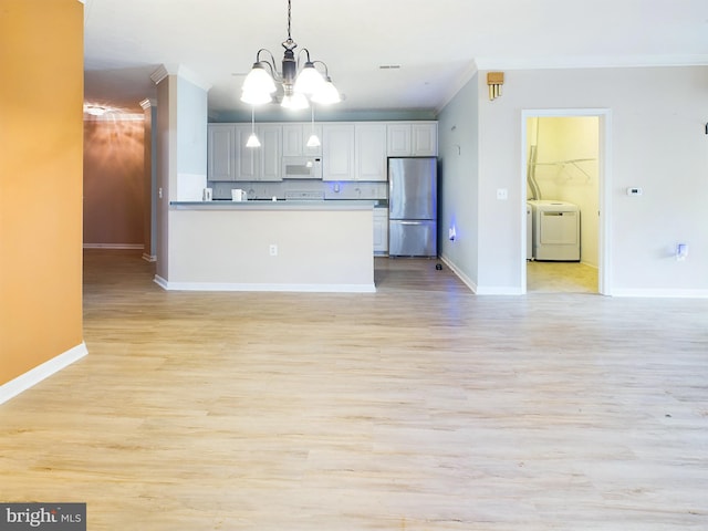 kitchen featuring stainless steel fridge, backsplash, ornamental molding, decorative light fixtures, and a chandelier