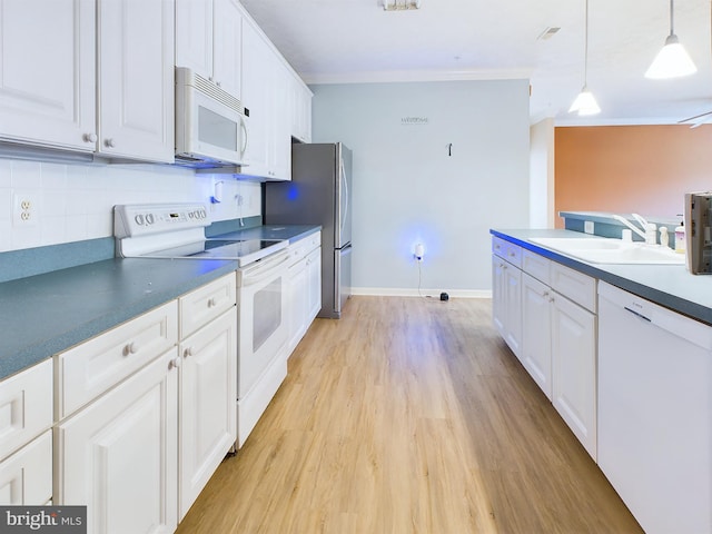 kitchen featuring white cabinetry, sink, hanging light fixtures, and white appliances