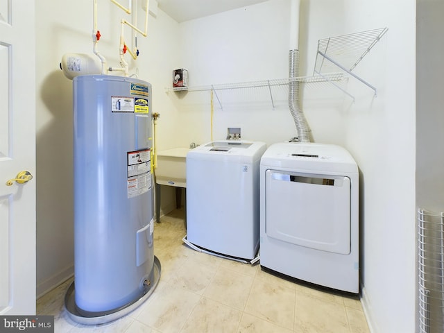 laundry area with water heater, sink, light tile patterned floors, and washer and dryer