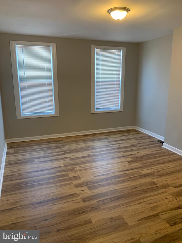 unfurnished room with dark wood-type flooring and a wealth of natural light