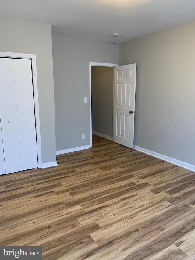 unfurnished bedroom with a closet and wood-type flooring