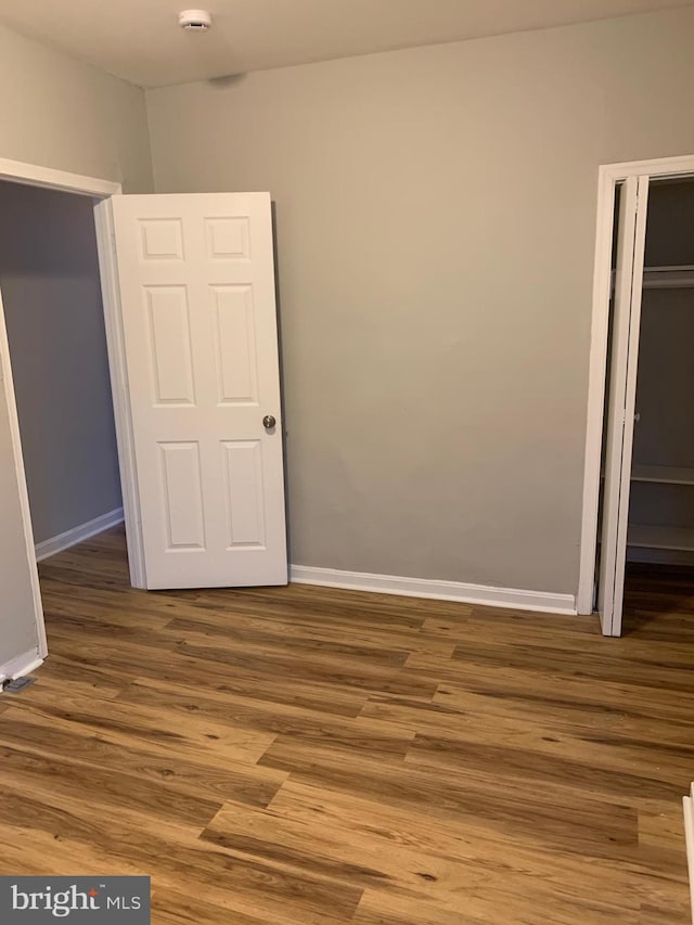 unfurnished bedroom featuring hardwood / wood-style floors and a closet