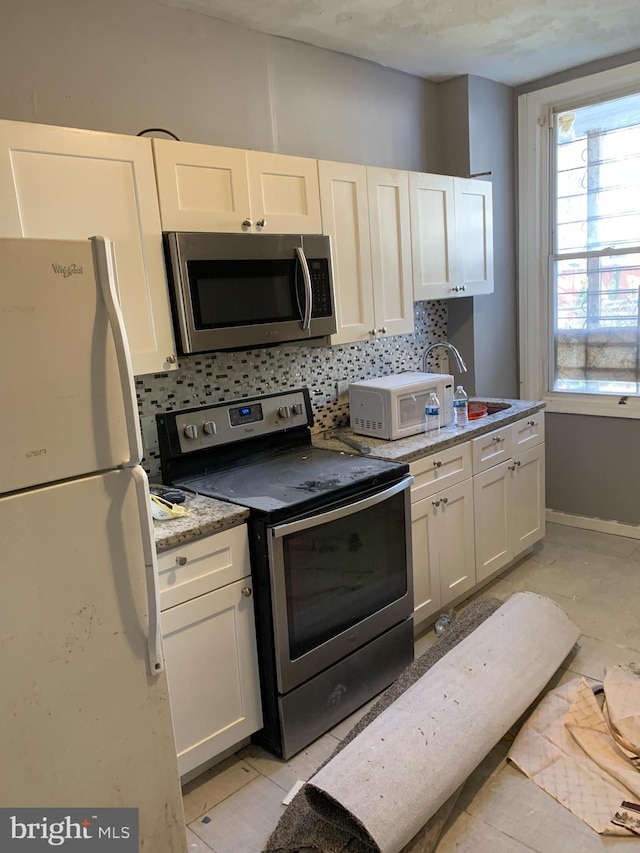 kitchen with decorative backsplash, sink, white cabinets, and stainless steel appliances