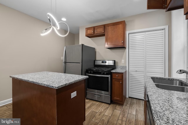 kitchen with light stone counters, light hardwood / wood-style flooring, stainless steel appliances, and sink