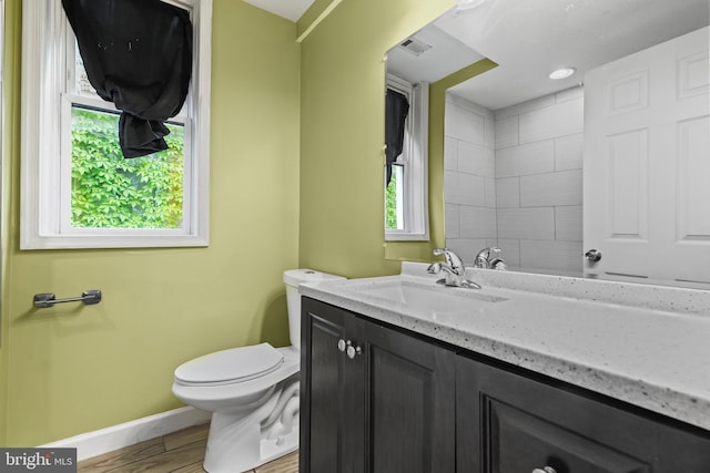 bathroom with hardwood / wood-style flooring, vanity, and toilet