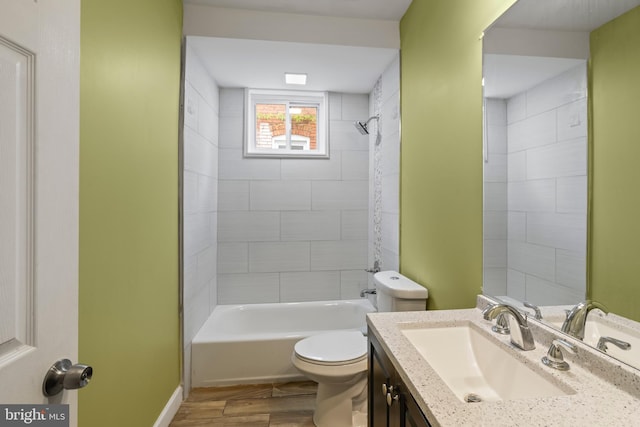 full bathroom featuring vanity, hardwood / wood-style flooring, toilet, and tiled shower / bath combo