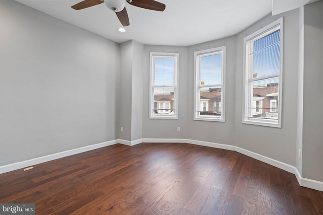 empty room with ceiling fan and dark hardwood / wood-style flooring