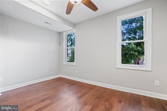 spare room with hardwood / wood-style flooring, ceiling fan, and a healthy amount of sunlight