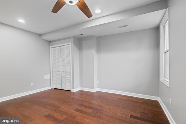 unfurnished bedroom featuring ceiling fan, dark wood-type flooring, and a closet